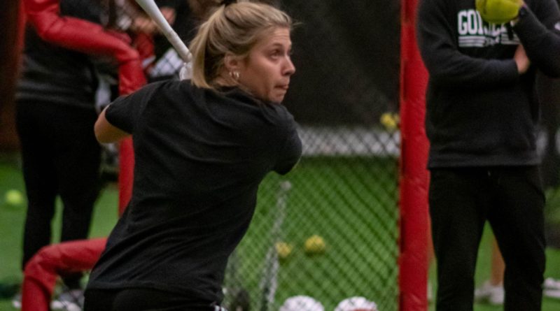 PSU Softball senior captain Taylor Lambert is practicing her batting skills with Coach Brad Fuller watching on in the indoor practice facility during a rainy day on Wednesday, February 8.